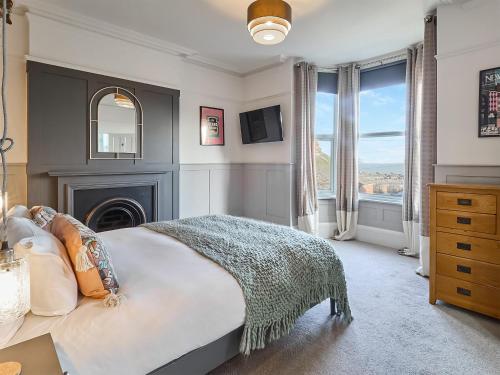 a bedroom with a large bed and a fireplace at Belmont House in Broadstairs