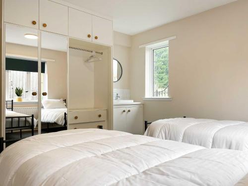 アルトンにあるGreenwaysの白いベッドルーム(ベッド2台、鏡付)