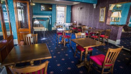 a restaurant with tables and chairs in a room at The Embassy Hotel in Great Yarmouth