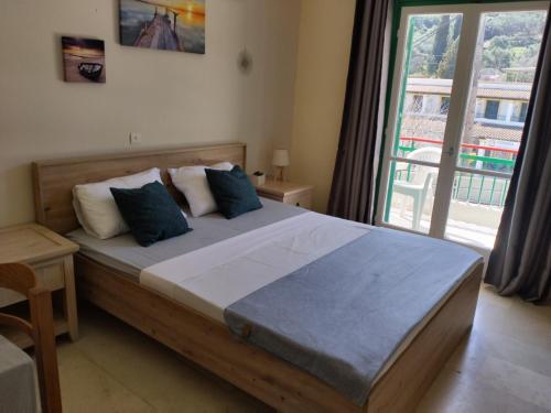 een slaapkamer met een groot bed en een groot raam bij Jimmy's Apartments in Moraitika