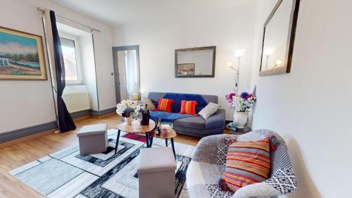 un salon avec un canapé bleu et une table dans l'établissement Les Cigognes d'Alsace, à Colmar