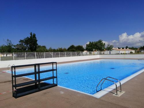 une grande piscine bleue avec une balustrade métallique dans l'établissement ma petite maison du bord de mer, à Bretignolles-sur-Mer