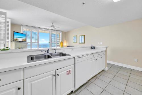 a kitchen with white cabinets and a sink at Majestic Beach Towers 1-1615 in Panama City Beach