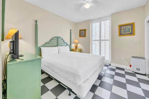 a bedroom with a bed and a tv and a checkered floor at Majestic Beach Towers 1-1615 in Panama City Beach