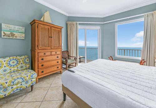 ein Schlafzimmer mit einem Bett, einer Kommode und einem Fenster in der Unterkunft Grandview East 1503 in Panama City Beach