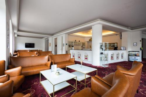un restaurante con sofás y mesas en una habitación en Milling Hotel Saxildhus, en Kolding