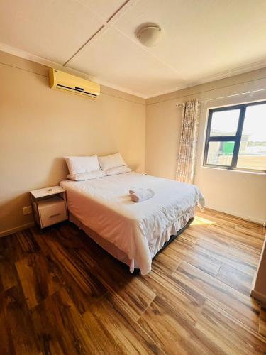 ein Schlafzimmer mit einem großen Bett und einem Fenster in der Unterkunft Morningside41 in Ongwediva