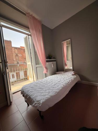 トリノにあるBnB Sakura Via Napioneのベッドルーム1室(ベッド1台、大きな窓付)