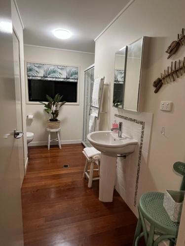 a bathroom with a sink and a mirror at The Cowrie Shell, Hydeaway Bay in Hideaway Bay