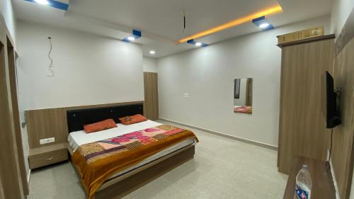 a bedroom with a bed and a television in it at Paradise residency and cafe in Gwalior