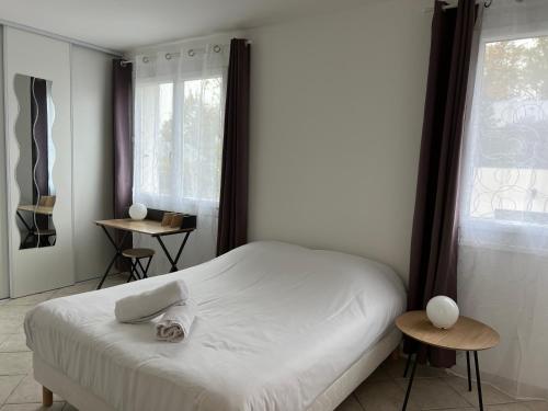 方蒂提斯的住宿－La douceur au coeur des chateaux de la Loire，卧室配有白色的床和2扇窗户。