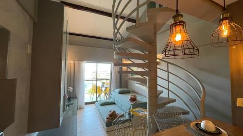 eine Wendeltreppe in einem Wohnzimmer mit einem blauen Sofa in der Unterkunft Laguna Beach Flat in Porto De Galinhas