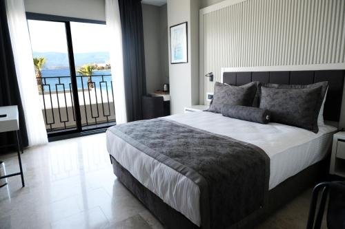 1 dormitorio con 1 cama grande y balcón en ROSEIRA MAR-INN LUXURY en Gulluk