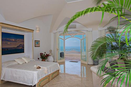 a bedroom with a bed and a view of the ocean at Villa Santa Chiara Positano Suites in Positano