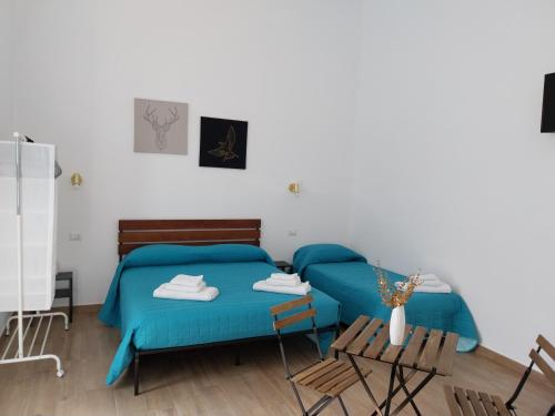 a bedroom with two beds and a table and chairs at BALO'S HOUSE in Bari