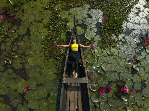 a woman standing on a rope bridge over a pond at Coconut Lagoon Kumarakom - A CGH Earth Experience in Kumarakom