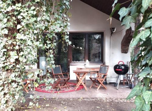 a patio with a table and chairs and a grill at Nest 4 Rest in Konstancin-Jeziorna