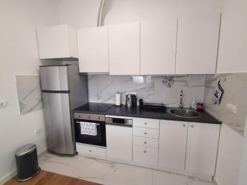 a white kitchen with a sink and a refrigerator at Zemun blue star in Zemun