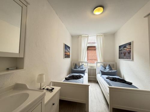a bathroom with two beds and a sink at Führs in Borkum