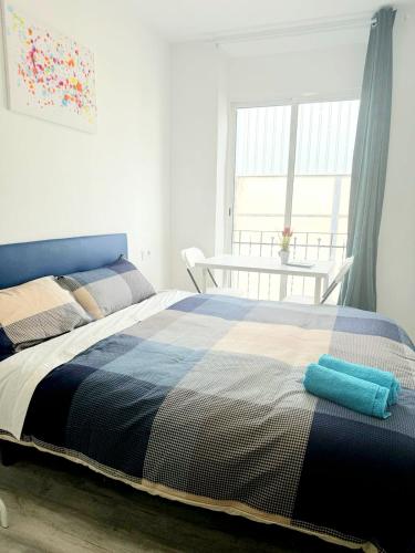 1 dormitorio con cama, mesa y ventana en Apartamentos Aeropuerto Valencia, en Manises