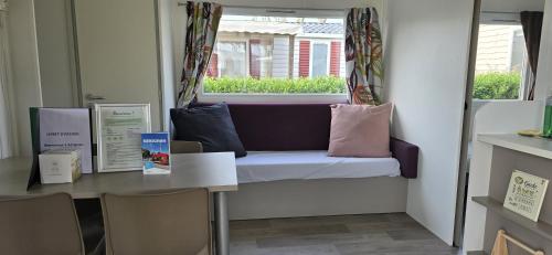 um quarto com um banco, uma mesa e uma janela em MOBIL HOME CAMPING LES SABLES DU MIDI em Sérignan