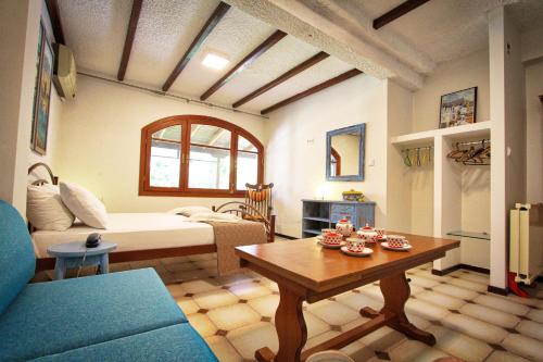 a living room with a bed and a table at Aquamarine Apartments in Paleo Tsifliki