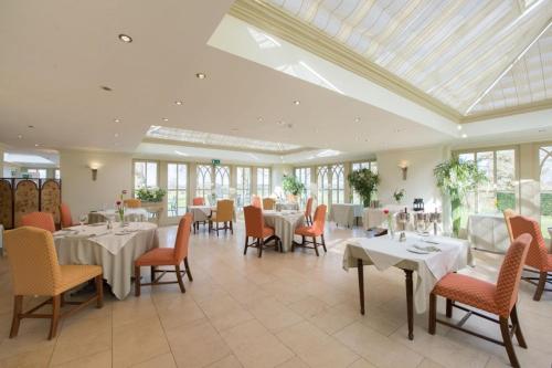 a dining room with tables and chairs and windows at The Old Vicarage in Bridgnorth
