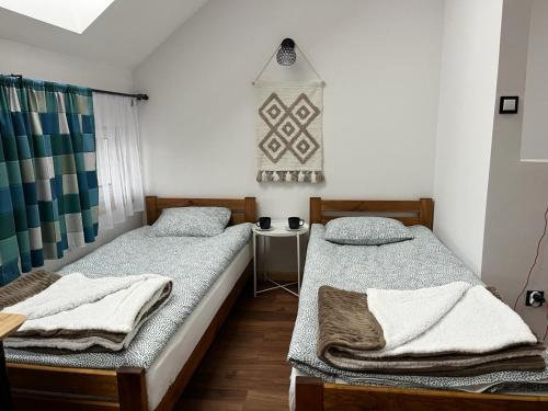 2 camas individuales en una habitación con ventana en Apartamenty Słoneczny Wieczór, en Braniewo