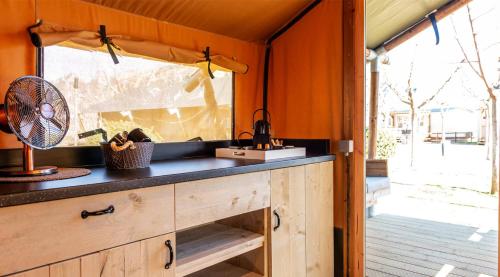 a kitchen in a caravan with a sink and a fan at La Noguera Camping in Sant Llorenç de Montgai