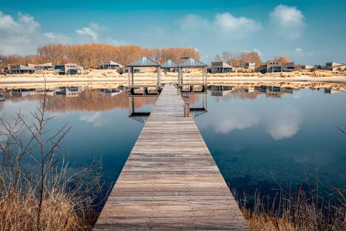 a wooden dock in the middle of a lake at Studio Deluxe | 2 Pers. Landzijde in Ouddorp