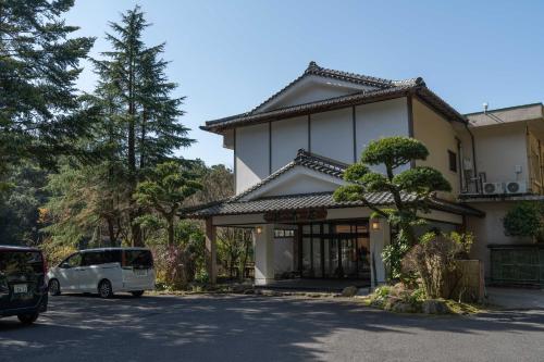 una furgoneta blanca estacionada frente a un edificio en Kirishima Momijidani Seiryuso, en Kirishima