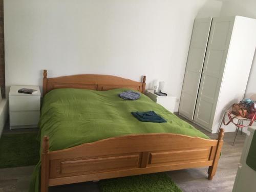 a bedroom with a wooden bed with a green blanket at Forsthaus am See Lychen in Lychen