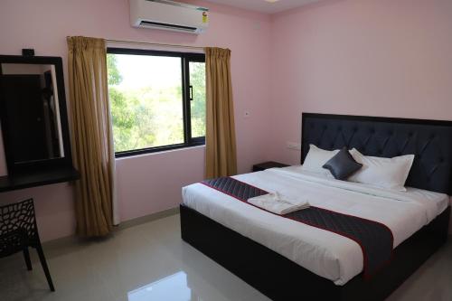 a bedroom with a large bed with a window at vimo boutique hotel in Auroville