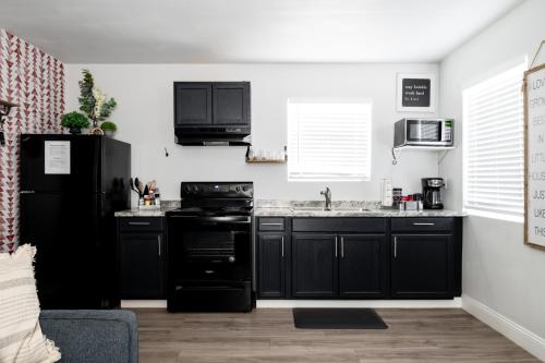 a kitchen with black appliances and a black refrigerator at Garofalo Cottage at Wrenwood Ranch, King Bed in Johnson City