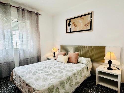 1 dormitorio con 1 cama con 2 lámparas y 2 mesas en CHALET BLAU MAR, en Peñíscola