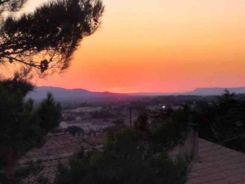 a sunset view of a city at sunset at Beau Duplex climatisé T3 vue panoramique Luberon in Pertuis