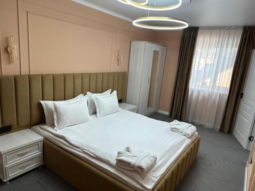 a bedroom with a large bed with towels on it at Вояж in Taraz