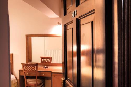 a room with a desk and a door with a mirror at Lesvion Hotel in Mytilene