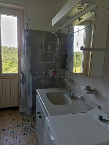 une salle de bain avec un lavabo, un miroir et une fenêtre dans l'établissement Maison de campagne Lot/Dordogne, à Rouffilhac