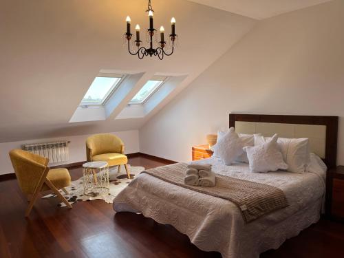 Un dormitorio con una cama grande y una lámpara de araña. en Dúplex Pico Sacro en Lestedo