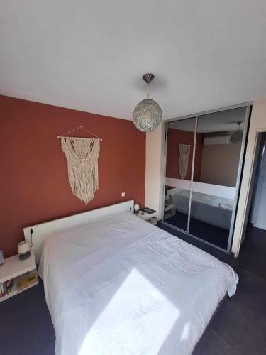 une chambre avec un grand lit et un grand miroir dans l'établissement Bel appartement moderne avec piscine, à Hyères