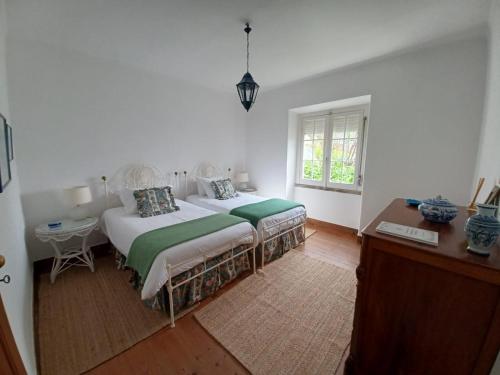 a bedroom with two beds and a desk and a window at GRANDMA BAY HOUSE in São Martinho do Porto