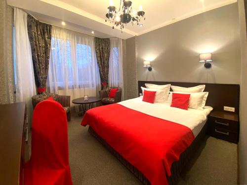a hotel room with a red bed and a table at Apartment Eney in Lviv