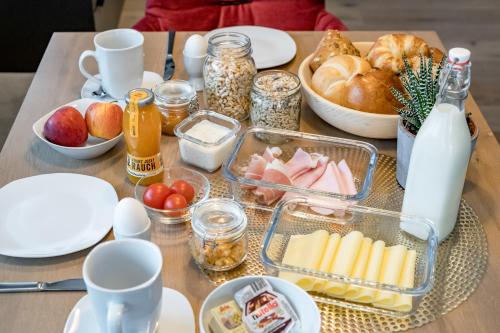 a table with breakfast foods and milk on it at Appartements Perberschlager in Oetz