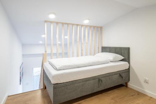 1 cama con cabecero de madera en una habitación en Baza Sopot en Sopot