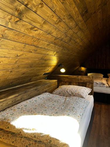 a bedroom with two beds in a wooden ceiling at Apartmány Vlachovice in Vlachovice