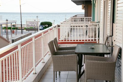 una mesa y sillas en un balcón con vistas al océano en Villa Zoi, en Paralia Katerinis