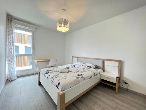 een witte slaapkamer met een bed en een raam bij Le Cartoucherie - 4p - Parking - Tram & Zénith in Toulouse