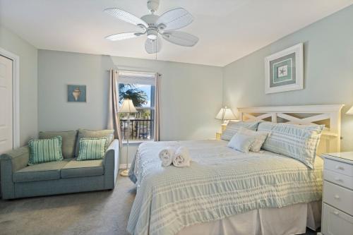 un dormitorio con una cama y una silla en Grand Caribbean East 214, en Pensacola