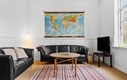 a living room with a couch and a world map on the wall at Nice Home In Tim With Kitchen in Tim
